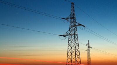 Pylons,And,Electricity,Powerlines,At,Night,With,Traffic,Lights